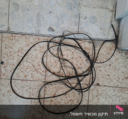 כבלים שחורים מונחים על רצפה מרוצפת